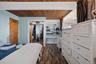 Wood-finish flooring throughout, complemented by a wood-paneled ceiling with exposed beams