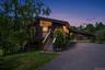 Contemporary-style residence featuring a dark exterior, elevated deck, and prominent exterior staircase