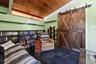 Interior space featuring a sloped wood-finish ceiling, black tile flooring, and custom wood barn doors with black metal hardware