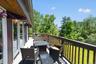 Expansive outdoor deck featuring wood-finish railing, composite decking, and multiple glass-paneled doors