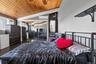 Vaulted wood-paneled ceiling with a ceiling fan, mirrored closet doors, dual windows, and built-in shelving