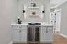 Custom dry bar featuring a white countertop, light gray cabinetry, and an integrated beverage cooler