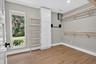 Room featuring wood-finish flooring, white baseboards, and light gray walls
