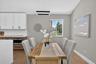 Dining area featuring wood-finish flooring, a contemporary linear chandelier, and a window providing natural light