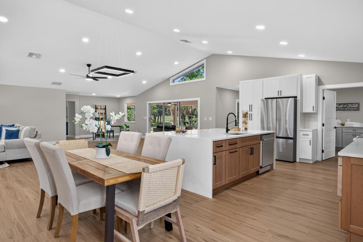Vaulted ceilings with recessed lighting, wood-finish flooring, and a contemporary ceiling fan