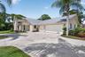 Contemporary stucco exterior with a metal roof and an expansive concrete driveway