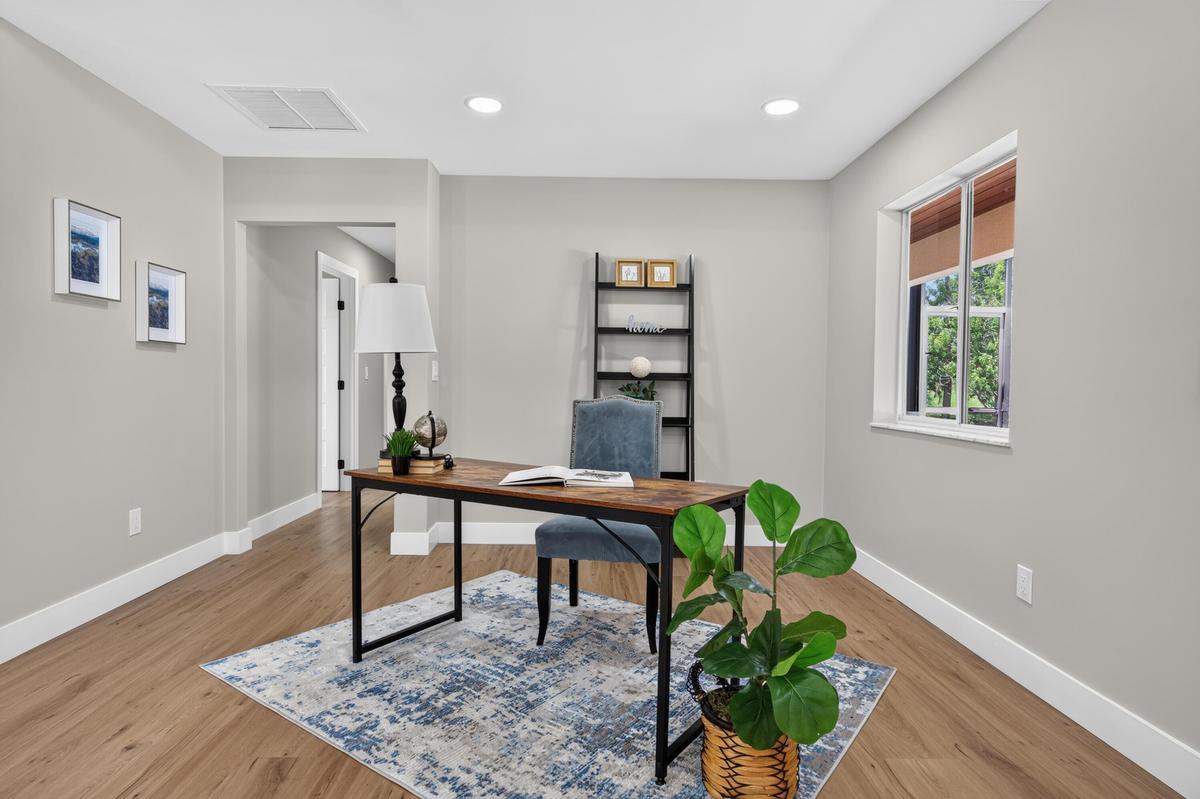 Room featuring wood-finish flooring, recessed lighting, a single window, and a doorway