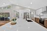 Gourmet kitchen featuring a large island with an undermount sink, a black matte pull-down faucet, and built-in power outlets