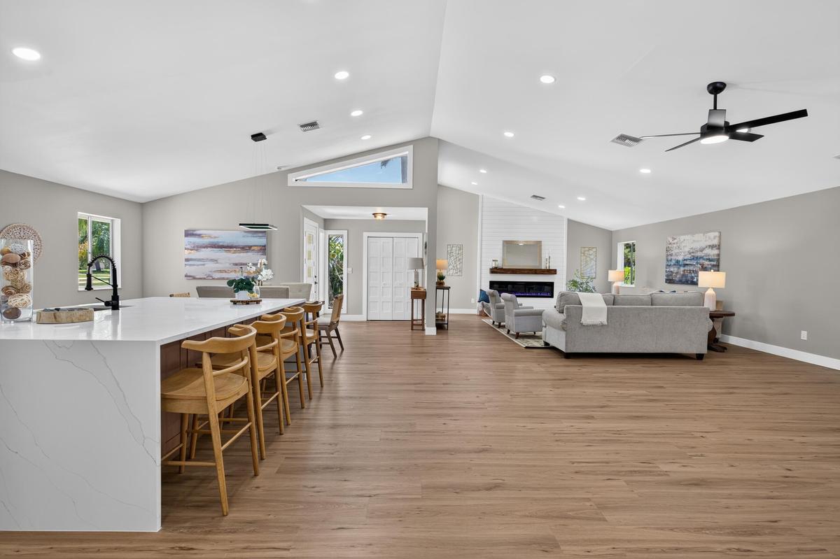Expansive open-concept interior featuring wood-finish flooring, vaulted ceilings, and recessed lighting
