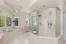 Designed for modern luxury, this primary bathroom includes a spacious glass shower and beautifully appointed details.