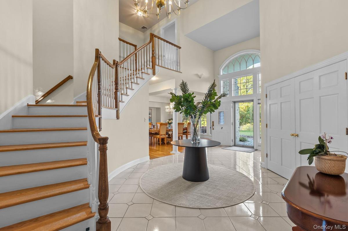 An elegant grand foyer filled with natural light and classic architectural details.