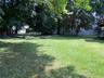 Spacious wide open private flat backyard with wooden swing and room for a pool or possibly even a pickleball court