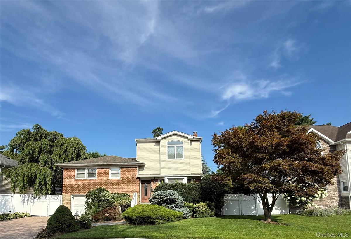 Well-maintained brick and vinyl-sided split-level, paver driveway, and manicured landscaping. Move-in ready with great curb appeal