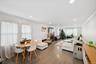 Living area with ornamental molding, dark wood-style floors, a stone fireplace, recessed lighting, and a wall mounted AC