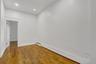 Room featuring wood-finish flooring, white walls, recessed ceiling lighting, and baseboard trim