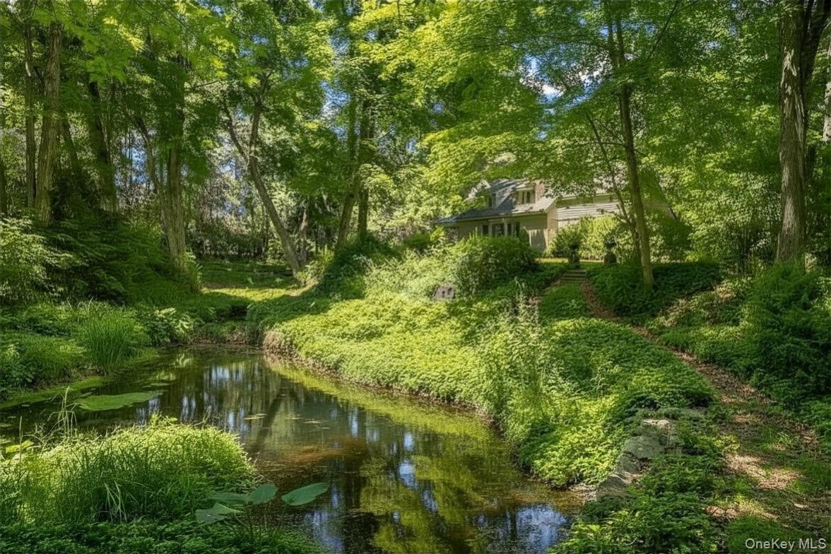 A truly magical entrance includes an exquisite pond with beautiful gardens