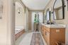 Spacious primary bath with shower and soaking tub is one of 3.5 bathrooms