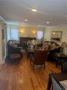 Living space featuring wood-finish flooring, recessed lighting, and a prominent fireplace with a dark wood mantel