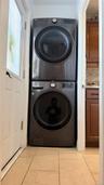 Stackable laundry appliances with front-loading design, set within a dedicated alcove