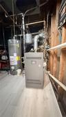 Mechanical room featuring a new gas furnace unit, hot water heater,