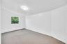Bright room featuring neutral carpeting and white painted walls