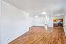 Spacious room featuring wood-finish flooring, white walls, and flush-mount ceiling lighting