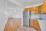 Kitchen featuring wood cabinetry, stainless steel refrigerator, white countertop, and a stainless steel sink with a gooseneck faucet