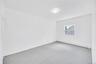 Bright room featuring a single window, white walls, gray carpet, a flush-mount ceiling light, and baseboard heating