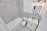 Bathroom featuring a white vanity with integrated sink, brushed nickel faucet, and a wall-mounted mirror