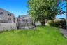 Expansive green lawn with a mature tree providing natural shade