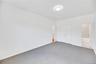 Spacious room featuring neutral carpeting, white walls, and a contemporary flush-mount ceiling light