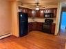 Kitchen featuring wood-finish flooring, dark wood cabinetry, and a ceiling fan