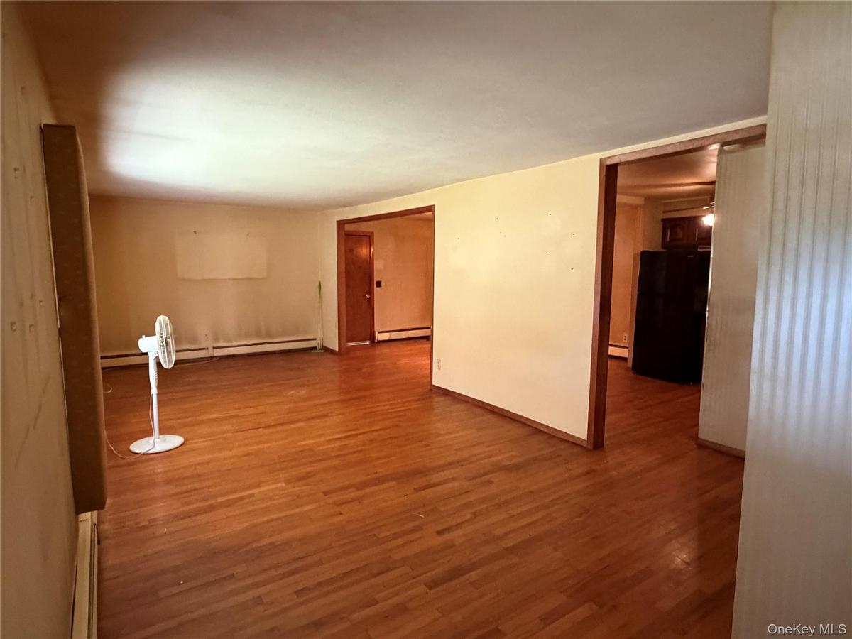Hardwood flooring throughout featuring light-toned walls and contrasting darker trim