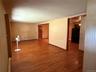 Hardwood flooring throughout featuring light-toned walls and contrasting darker trim