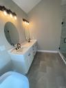 The custom vanity is accented by designer lighting, contemporary fixtures, and sophisticated finishes that elevate the space with timeless style.