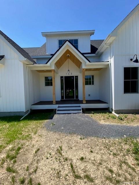 The covered porch extends the home’s living space outdoors, creating an inviting setting for conversation and relaxation.