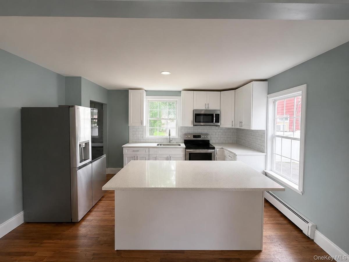 Kitchen with counter top. Access to rear and lower level basement.