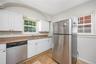 Kitchen featuring white cabinetry, a stainless steel refrigerator, and stainless steel dishwasher