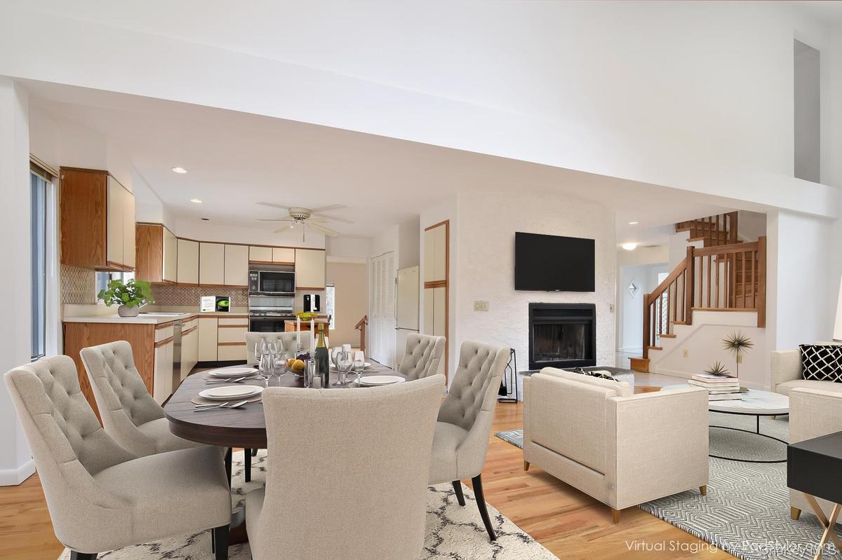 Virtually stagedDining area with vaulted ceiling, light wood floors, a fireplace and recessed lighting