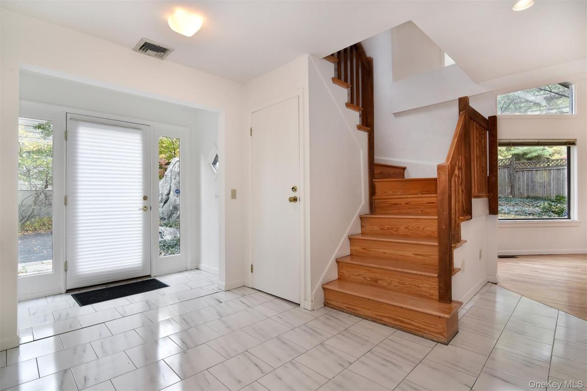 Light filled Foyer entrance with stairway and 2 closets