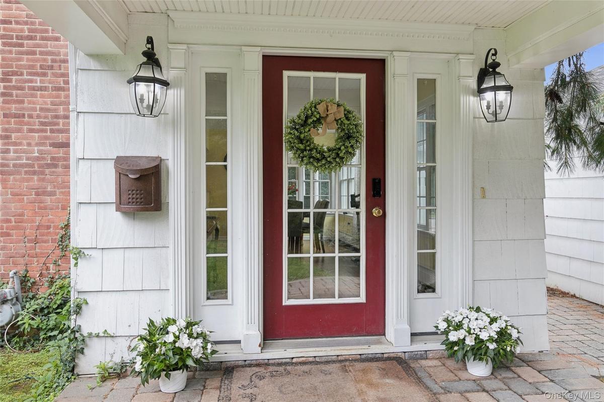 Covered side door entrance with delightful porch overlooks the side/front yard.