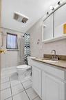 White vanity with a stone-finish countertop and undermount sink
