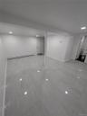 Basement with a baseboard radiator, recessed lighting, marble finish floor, and baseboards