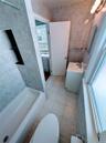 Bathroom featuring vanity, tile patterned floors, toilet, a tub to relax in, and tile walls