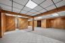 A finished lower level bonus space spanning approximately one thousand square feet, detailed with real wood wall planking, a full summer kitchen, and 