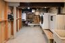 Laundry area featuring a utility sink, exposed wood support beams, and concrete flooring