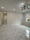 Spacious room featuring large format tile flooring, recessed lighting, and a modern chandelier