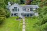 The stunning rear of the home showcases beautiful outdoor living spaces and multiple levels with breathtaking lake views. Lawns for badminton and bocc