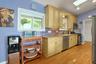 The kitchen windows frame peaceful views of the frontyard and garden, bringing natural light and the surrounding greenery in. At this end lies a mudro
