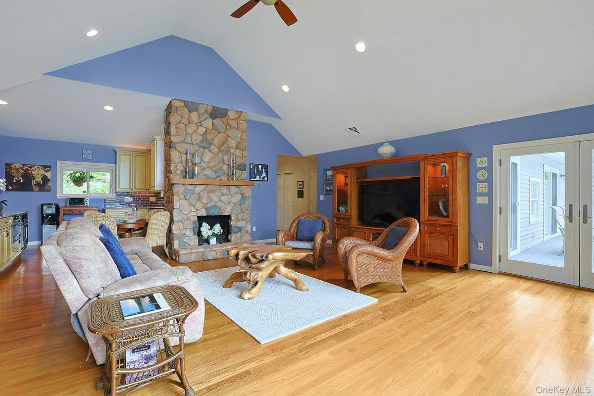 The heart of this home features a stunning stone fireplace. The living room opens to the  kitchen, dining room and the deck, all with beautiful lake v